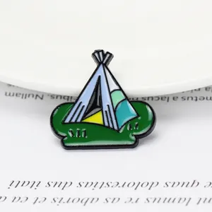 Detailansicht einer hellblauen Tipi-Camping-Emaille-Nadel auf einem Buchhintergrund