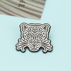 Macro shot of a stylized black and white leopard enamel pin with detailed metal texture