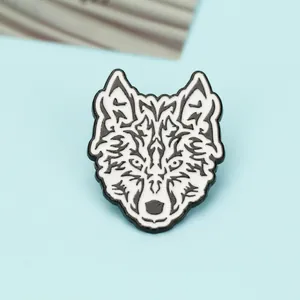 Detailed view of geometric wolf head enamel brooch with tribal patterns on blue background