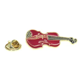 Detailed close-up of a red violin brooch with gold trim and butterfly clasp back