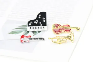 Detailed close-up of colorful violin, piano, and trumpet enamel pins on a book page