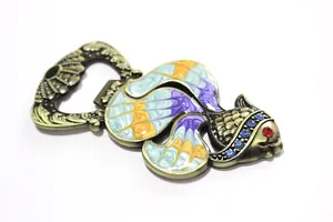 Detail of fish-shaped bottle opener with colorful enamel patterns and blue rhinestones