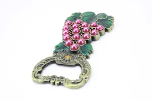 Detailed view of grape-shaped zinc alloy beer opener with pink pearls and green enamel