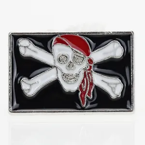 Dettaglio di una spilla smaltata a forma di teschio pirata con bandana rossa e ossa