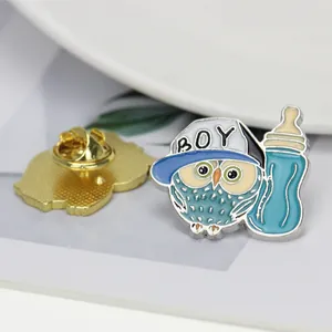 Détail de l'épinglette chouette émaillée avec casquette BOY, biberon et fermoir papillon doré