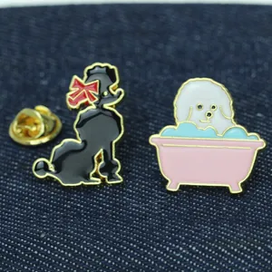 Macro shot of two dog enamel pins featuring a black poodle and white dog in a pink bathtub
