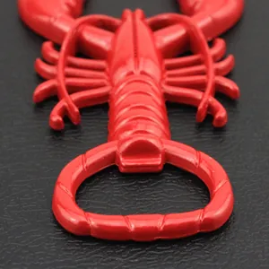Close-up of the red crawfish bottle opener hook on a dark textured leather surface