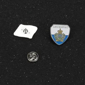 Macro detail of San Marino flag shield pin showing front crest and butterfly clutch back
