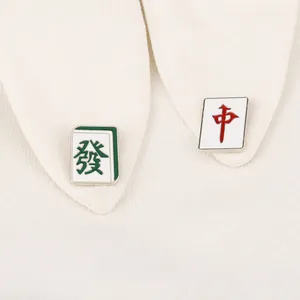 Détail de broches en émail sur le thème du Mahjong sur le col d'une chemise blanche