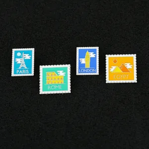 Detail of four vintage enamel pins featuring world landmarks in retro stamp designs