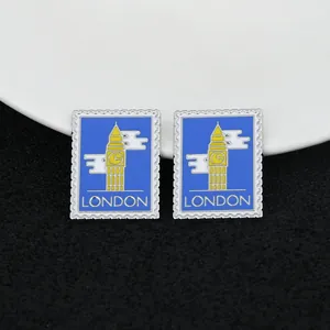 Detailed macro view of two London Big Ben enamel stamp pins on black matte surface