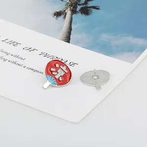Λεπτομέρεια κόκκινης καρφίτσας βεντάλιας με κείμενο και μεταλλικό κούμπωμα