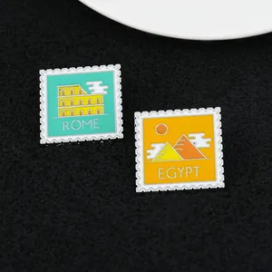Detail of enamel stamp brooches featuring Rome Colosseum and Egypt Pyramids icons