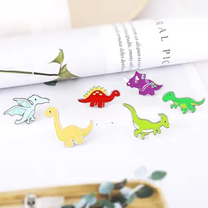 Close-up of six colorful enamel dinosaur pins including triceratops and stegosaurus