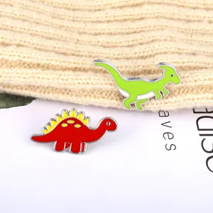 Cute cartoon enamel dinosaur brooch set featuring green parasaurolophus and red stegosaurus