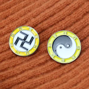 Makroaufnahme von Emaille-Anstecknadeln mit Yin Yang und Bagua-Symbolen auf Stoff