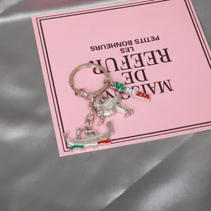 Silver metal Venice souvenir keychain featuring winged lion and gondola on silk background