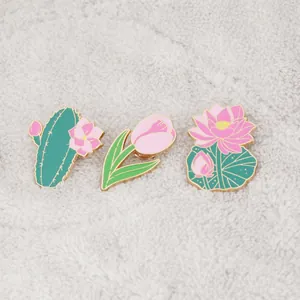 Three-piece set of tulip, cactus, and lotus enamel pins with gold trim on white fur