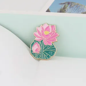 Detailed close-up of a pink lotus enamel brooch with green leaf and golden edges