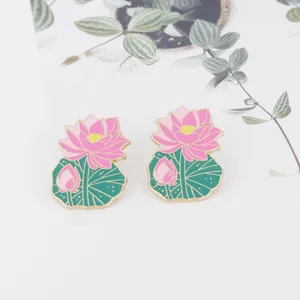 Macro detail of tulip flower brooch with pink petals, yellow stamens and green leaves