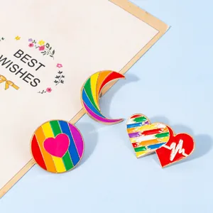 Rainbow enamel brooch set featuring heart and moon designs with gold metal edging