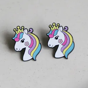 Detail of colorful unicorn enamel pin with golden crown and floral patterns