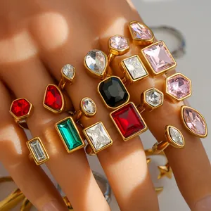 Fashionable gold-plated rings set with colorful geometric crystals on a female hand