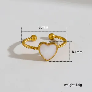Detail view of gold twisted heart ring with white enamel inlay and dimension labels
