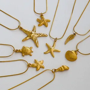 Detail of gold-plated stainless steel necklaces with ocean-themed pendants on snake chains