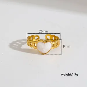 Golden open chain ring featuring a white heart charm and starburst engraving accents