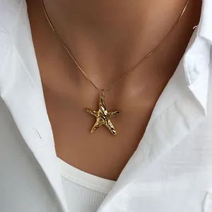 Detailed shot of a gold starfish pendant necklace on a delicate snake chain for women