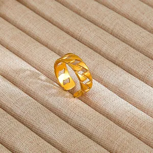 Detailed close-up of gold geometric chain ring set in a soft beige jewelry box