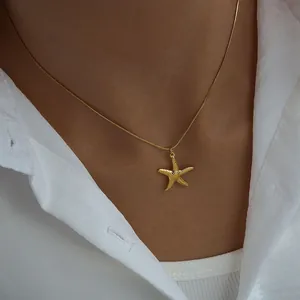 Detailed view of a gold-plated starfish pendant on a snake chain worn on the neck
