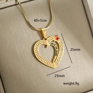 Detail view of 14k gold plated heart pendant with rhinestones and Love Me More engraving