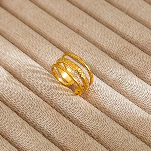 Macro view of gold multilayered hammered ring on a beige linen jewelry display tray