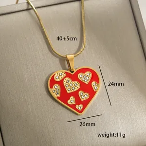 Macro detail of red enamel heart pendant with dimensions 24mm by 26mm on gold chain
