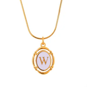 Detailed close-up of gold snake chain with oval hollowed-out pendant featuring letter W