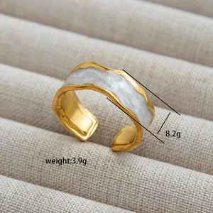 Detail of golden wavy open ring with white marble inlay weighing 3.9g and 8.2mm wide