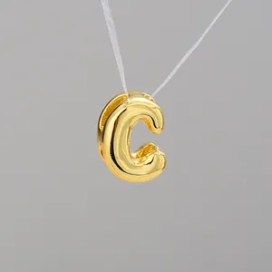 Macro view of 3D bubble letter C pendant with a high-polished gold mirror finish