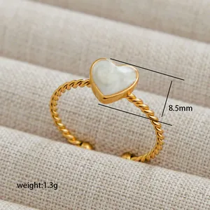 Close-up of golden rope band ring featuring a 8.5mm marble-textured heart charm