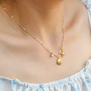 Halskette mit Seestern und Muschel aus 18K vergoldetem Edelstahl an einem Modell
