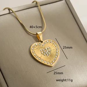 Macro view of 14k gold heart pendant with sunburst texture and sparkling rhinestones