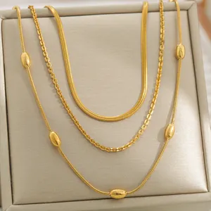Gros plan d'un ensemble de chaînes serpent dorées avec perles polies sur un coffret bijoux