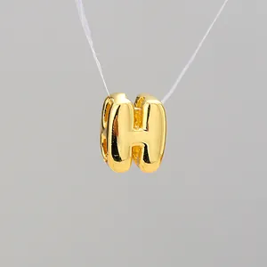 Macro detail of high-polished gold-plated bubble letter H pendant for DIY jewelry