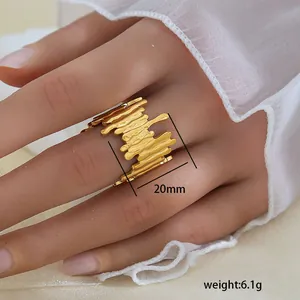 Detalle de anillo dorado ajustable con textura fluida, ancho de 20mm y un peso de 6,1g