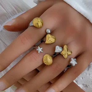 Close-up of assorted gold and silver stainless steel rings with floral and heart motifs