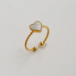 Détail d'une bague torsadée plaquée or avec incrustation en nacre en forme de cœur