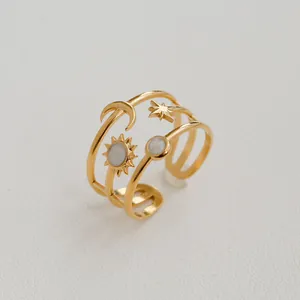 Détail d'une bague ajustable dorée à plusieurs rangs avec breloques de lune et d'étoiles