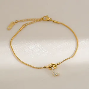 Detail van 18k vergulde slangenketting armband met zirkonia letter L bedel hanger