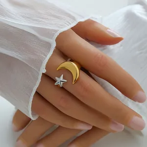 Detail view of gold moon and silver star ornaments on an adjustable open ring band